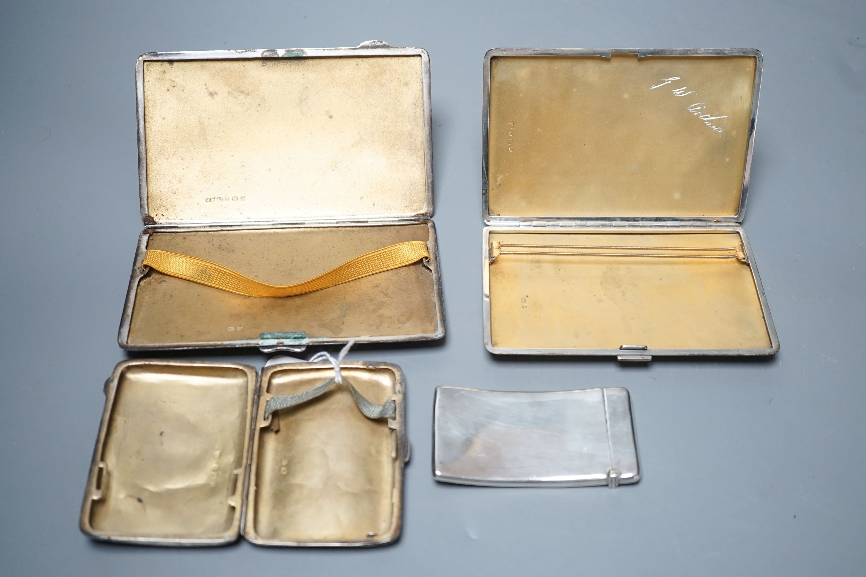 Three assorted silver cigarette cases and a silver card case, largest 14cm, gross 14oz.